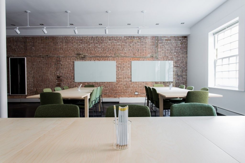 deux bureaux avec mur en brique et tableau blanc